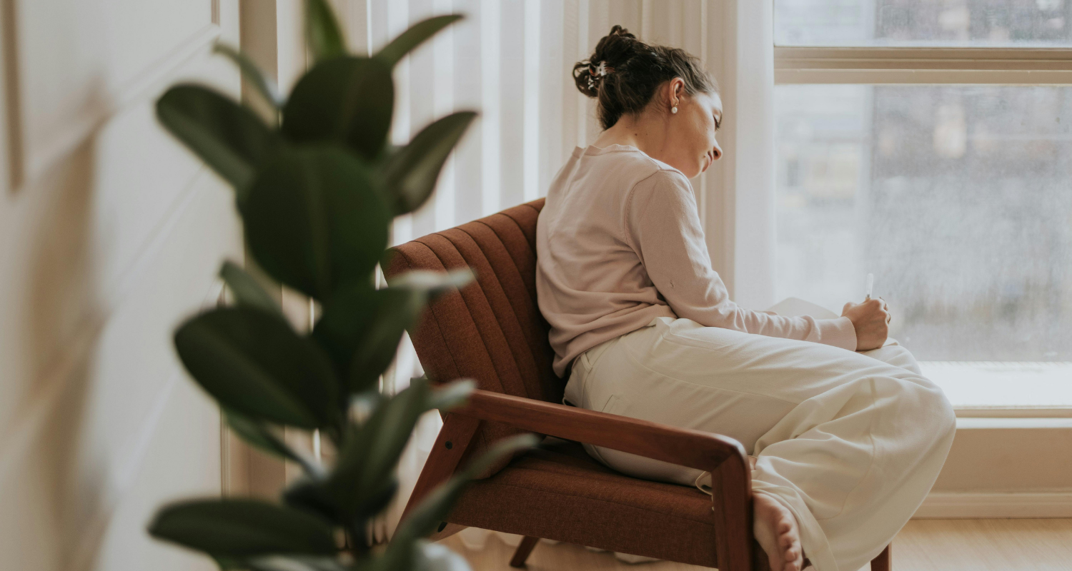 Woman writing peacefully by a sunlit window